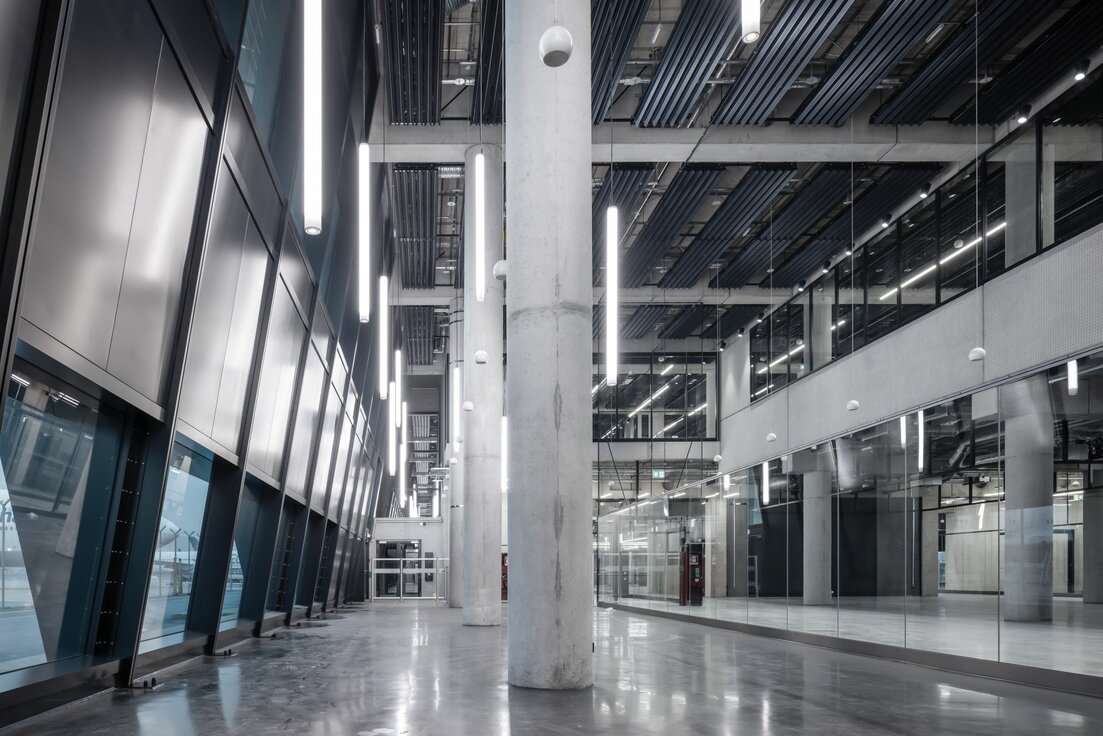 Pier G Terminal 3 Flughafen Frankfurt mit Y-Lamellen Heiz- und Kühldecke von Lindner, schräger Glasfassade und modernen Glastrennwänden im offenen Terminalbereich.