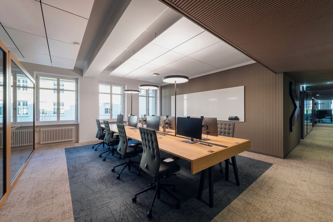 © Fotos: Peter Würmli © Evolution Design Moderne Büroinsel mit acht Arbeitsplätzen in hell gestaltetem Raum mit Holzoptik und warmem Ambiente | © Fotos: Peter Würmli © Evolution Design