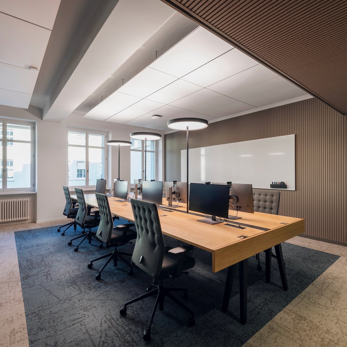 Moderne Büroinsel mit acht Arbeitsplätzen in hell gestaltetem Raum mit Holzoptik und warmem Ambiente | © Fotos: Peter Würmli © Evolution Design