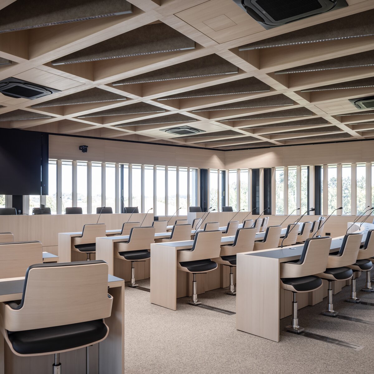 Moderner Sitzungssaal im Landratsamt Landshut mit hellem Holz, maßgefertigten Tischen und hochwertigem Innenausbau von Lindner Group | © © www.Lindner-Group.com